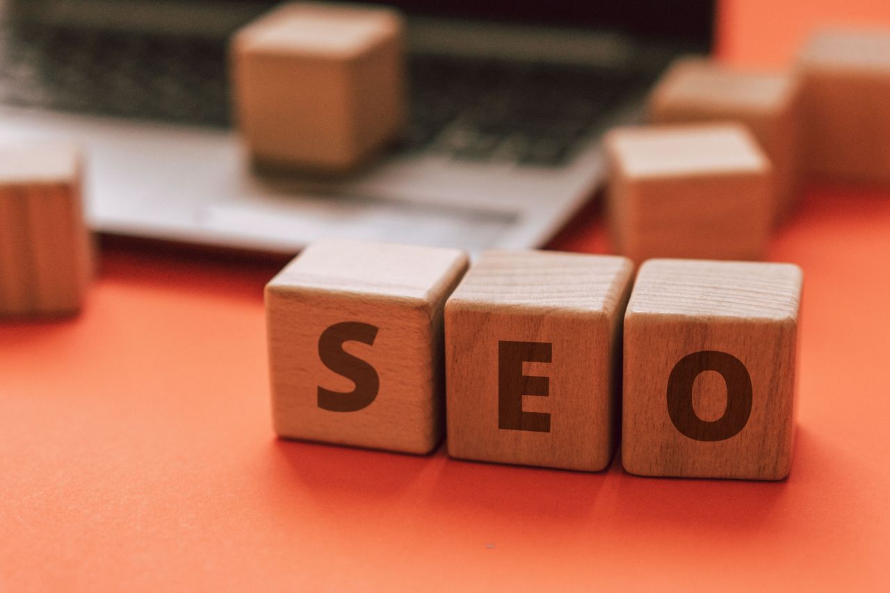 Des blocs de bois formant le mot SEO sur le clavier d’un ordinateur portable illustrent les concepts du marketing digital.